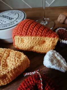 several crocheted items are sitting on a table next to a glass of wine