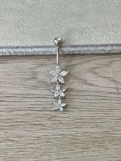 a silver belly ring with flowers on it