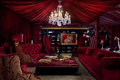 a living room with red couches and chandelier