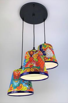 three colorful lights hanging from a ceiling fixture