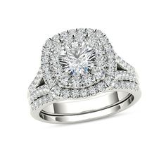 a white gold ring with an oval cut diamond surrounded by smaller round diamonds