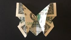 an origami butterfly made out of money on a black background with space for text