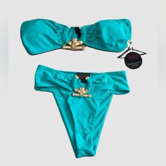 Get All The Looks When You Wear This Super Cute Two Piece Set Bikini. Made With Silky Fabric On A Padded Bandeau Top, Featuring A Gold Ring Detail On Both Top And Bottom To Complete The Look. Top Bandeau Padded Gold Ring Detail Double Lined Stretchy Fabric: 95% Poly- 5% Spandex Bottom High Waist Cheeky Gold Ring Detail Double Lined Stretchy Fabric: 95% Poly- 5% Spandex Crochet One Piece, High Cut Swimsuit, Hot Miami Styles, Black Bathing Suits, Silky Fabric, Miami Fashion, Swimsuits Halter, Mesh Long Sleeve, Bandeau Top