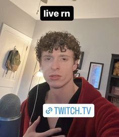 a young man with curly hair wearing headphones and holding a microphone in front of him