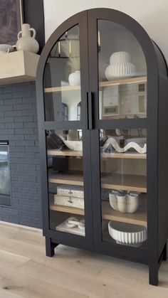 a black cabinet with glass doors and plates in it