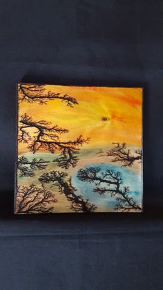 an acrylic painting of trees on a blue background with the sun setting in the distance