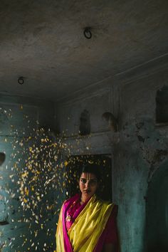 a woman wearing a yellow and pink sari