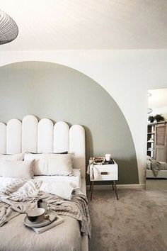 a bedroom with a large bed and white headboard