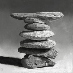 a black and white photo of rocks stacked on top of each other with one rock in the middle