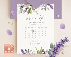 a wedding save the date card with purple flowers and greenery is displayed on a table