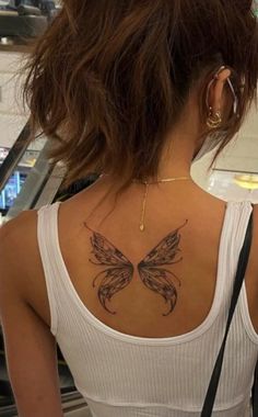 a woman with a butterfly tattoo on her back