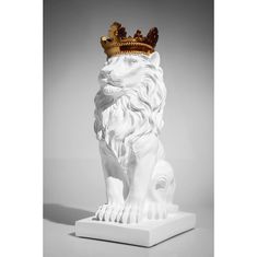 a white lion statue with a gold crown on top of it's head and legs