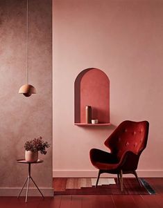 a chair and table in a room with pink walls