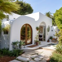 a white house with potted plants on the outside