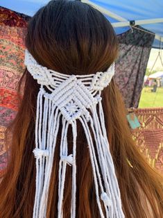 the back of a woman's head with white macrame tassels