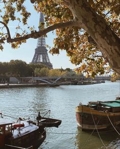 two boats are tied to the shore in front of the eiffel tower