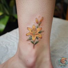 a yellow flower tattoo on the ankle