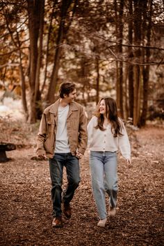 a couple walking through the woods holding hands