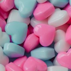 candy hearts in pastel blue, pink and white colors are scattered on top of each other