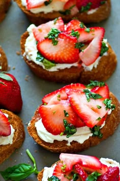 strawberries and whipped cream are on top of toasted bread with green leaves in the middle