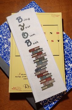 cross - stitch bookmarks are sitting on top of each other