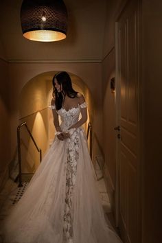 a woman in a wedding dress is walking down the stairs with her hand on her hip