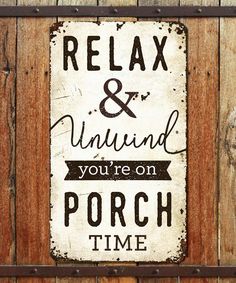 a sign that says relax and unwind you're on porch time hanging on the side of a wooden fence