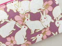 "This zipper pouch is made from Japanese cotton print. It is 100% cotton imported from Japan. This bag features white bunnies and a pink camellia on a lavender background with a metallic gold embellishments.  Fully lined with Japanese cotton fabric of a pink with a pin dot pattern. Zipper is hot pink and the zipper pull is accessorized with a pink enamel flower charm. Perfect purse for keeping small items such as compact digital camera, iPod, credit cards, etc. Dimensions (approx): Coin Purse: 3 White Rectangular Pouch With Pen Holders, White Pouch With Pen Slots For Daily Use, White Pouch With Pen Holders As Gift, White Pencil Case With Zipper Closure As Gift, Pink Camellia, Lavender Background, White Bunnies, Compact Digital Camera, Perfect Purse