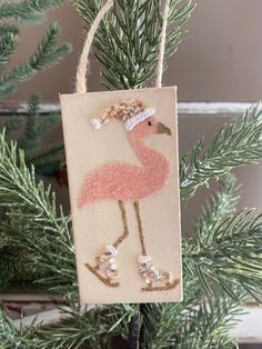 a pink flamingo ornament hanging from a christmas tree