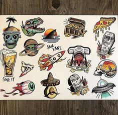 an assortment of stickers on a piece of paper that is laying on a wooden surface