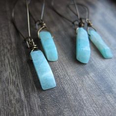 Like waters deep and ancient, Amazonite beckons in captivating shades of turquoise-green, promising to soothe the spirit and calm the soul. Its energy is as powerful as the river for which it is named, and as bold as the legendary women warriors with whom it is connected. Harness your inner goddess in a pair of these today! ★ Hand selected all natural raw amazonite gemstones ★ Ready to ship in 1-2 days ★ Crystals range 20-25mm long ★ These hang approx. 2.5" ★ Aged brass kidney ear wires ★ Crysta Amazonite Drop Earrings As Gift, Green Spiritual Earrings For Healing, Spiritual Turquoise Earrings With Natural Stones, Turquoise Natural Stones Spiritual Jewelry, Turquoise Natural Stones Holistic Jewelry, Holistic Turquoise Jewelry With Natural Stones, Turquoise Dangle Earrings With Amazonite, Turquoise Amazonite Dangle Earrings, Handmade Turquoise Amazonite Earrings