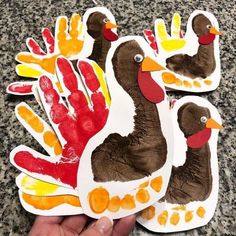 two handprinted ducks are being held by someone