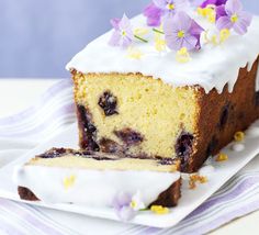 a piece of cake with white frosting and blueberries