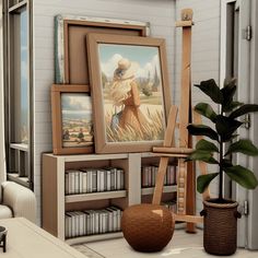 there is a painting on the easel next to bookshelves and a potted plant