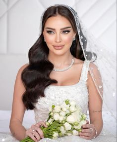 a woman in a wedding dress holding a bouquet of flowers