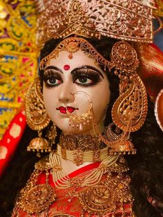 a close up of a doll with makeup on it's face and headdress