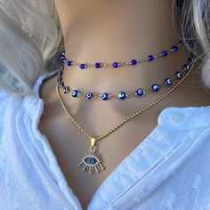 "These beautiful Blue evil eye choker gold are perfect to wear every day and protect yourself with positive energy. Talismans created to protect against the evil eye are also frequently called \"evil eyes\". '.'.'.'.'. * Chain 1: blue rosary chain gold plated. * Chain 2: made with evil eye beads on a gold plated chain enamel stainless steel. * Chain 3: ball chain with dainty evil eye charm cubic zircon. * Choose between this large variety of chains! * Fully finished with a matching 2 \"adjustabl Evil Eye Choker, Empath Protection, Hamsa Jewelry, Lucky Jewelry, Evil Eye Necklace Gold, Choker Gold, Raw Crystal Necklace, Amulet Necklace, Layered Necklace Set