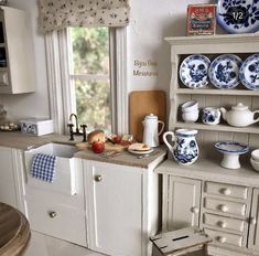 an old fashioned kitchen with blue and white dishes