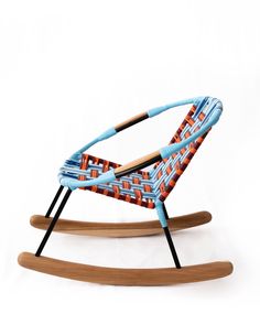 a wooden rocking chair with blue and orange fabric on the back, in front of a white background