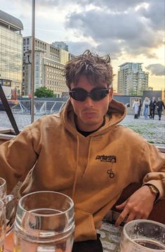 a man sitting at a table with glasses on it