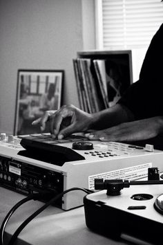 a dj mixing music on his turntable in front of a cd player and record player