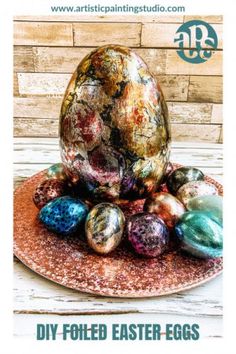 an easter egg sitting on top of a plate with other eggs in the background and text overlay that reads diy foiled easter eggs