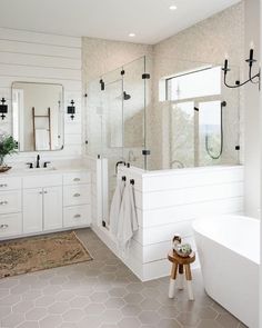 a white bathroom with two sinks and a bathtub