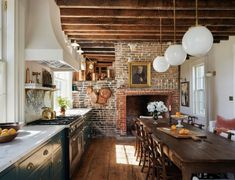 the kitchen is clean and ready to be used for dinner or breakfast time, with an old brick fireplace in the center