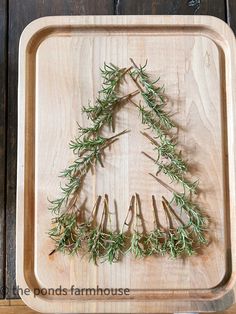 a wooden cutting board with rosemary on it