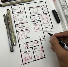 a person is drawing a floor plan with markers