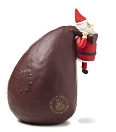 a santa clause figurine is on top of a chocolate egg shaped like an egg