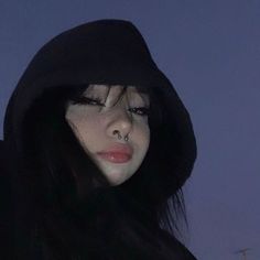 a woman with long black hair wearing a hoodie