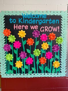 a bulletin board with flowers on it that says welcome to kindergarten here we grow