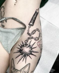 a woman's leg with tattoos on it and various items around the thigh,